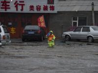 长春暴雨 市政工人站排水口一天防止事故