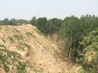 郑州一水库涵养林被倒大量建筑垃圾 一车100元
