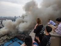 杭州一市场发生火灾 市民冒险爬楼顶围观