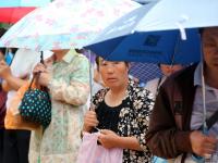 山东泰安大雨来袭 家长坚持雨中候考