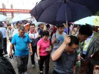 山东泰安大雨来袭 家长坚持雨中候考