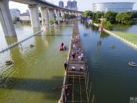 武汉汤逊湖淹水 路面开始铺设临时人行栈道