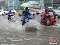 郑州暴雨致路面积水严重 行人如过河
