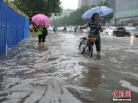 郑州暴雨致路面积水严重 行人如过河