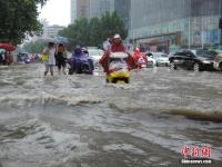 郑州暴雨致路面积水严重 行人如过河