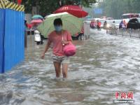 郑州暴雨致路面积水严重 行人如过河