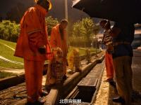 北京大雨夜 上千养路工人通宵执勤睡路边