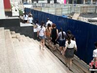 郑州“钢钩阵”广场被封 市民进出大厦走竹排