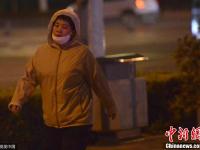 沈阳夜间温度接近0℃ 市民捂头遮面包裹严实
