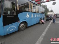 大巴被限高杆卡住引拥堵 司机为轮胎放气