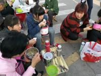 高考临近 “高考工厂”门口学生蹲地上吃饭