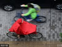 北京迎明显降雨天气 民众带雨具出行