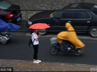 北京迎明显降雨天气 民众带雨具出行