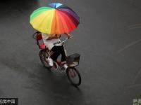 北京迎明显降雨天气 民众带雨具出行