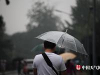 北京迎明显降雨天气 民众带雨具出行