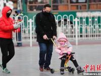北京急速降温 民众全副“武”装防寒出行