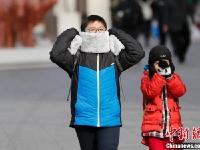 北京急速降温 民众全副“武”装防寒出行