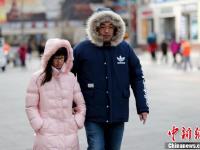 北京急速降温 民众全副“武”装防寒出行