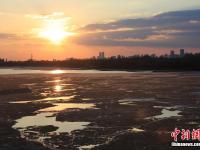 哈尔滨现“半江流水半江冰”