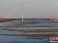  哈尔滨现“半江流水半江冰”
