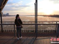  哈尔滨现“半江流水半江冰”